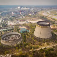 Opuszczone chłodnie kominowe elektrowni atomowej, które miały działać, gdy wybuchł Czarnobyl. W tle widać kompleks budynków i rzekę.