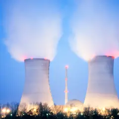 Dwie chłodnie kominowe elektrowni atomowej w Polsce wydzielają parę. W tle widać kopułę reaktora i wieżę.